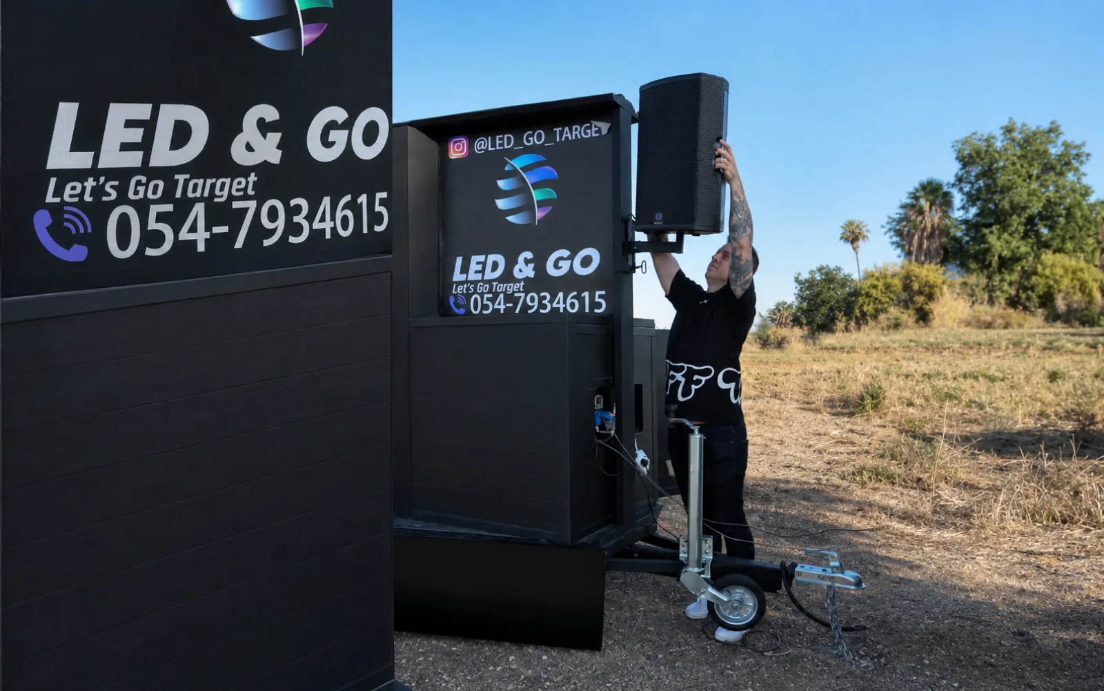 אדם מתקין רמקול לצד יחידת מסך LED ניידת