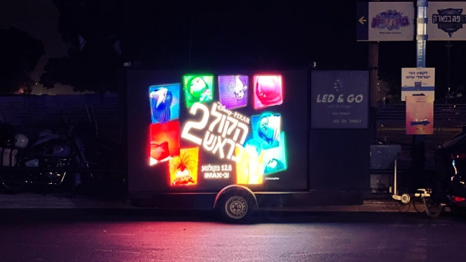 מסך LED נייד מציג בלילה את כרזת הסרט הכל בראש 2