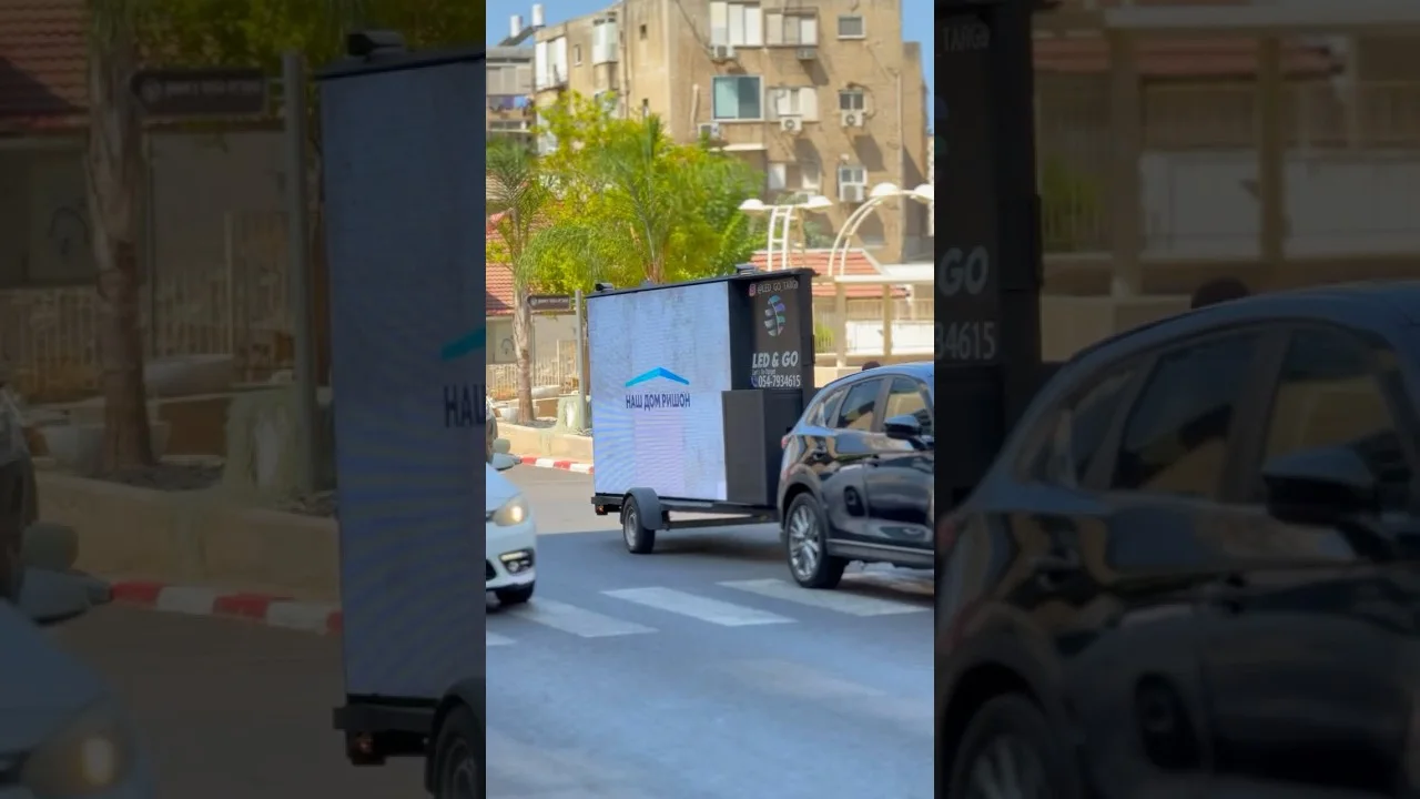 נגרר LED & GO נוסע ברחוב עירוני בין כלי רכב